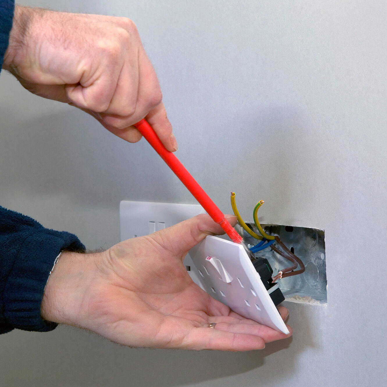 electrician fixing a plug socket